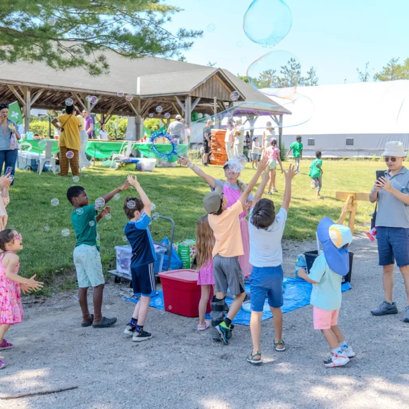Participants et enfants jouant avec des bulles lors de la Fête de la Saint-Jean-AFRY 2026 à Aurora