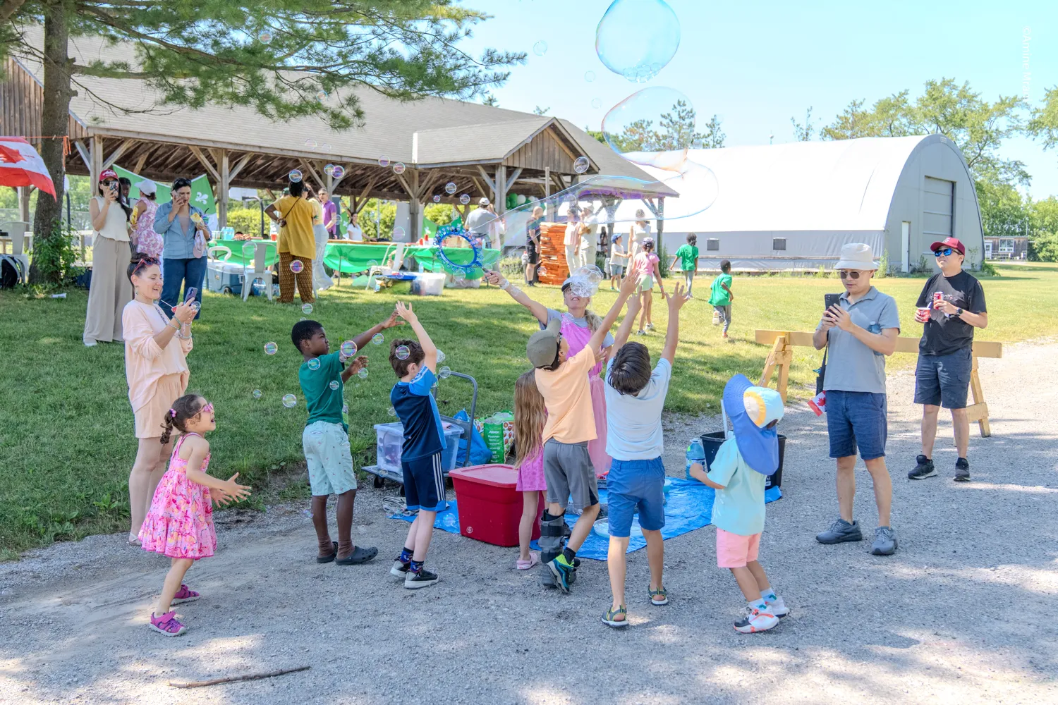 Participants et enfants jouant avec des bulles lors de la Fête de la Saint-Jean-AFRY 2026 à Aurora
